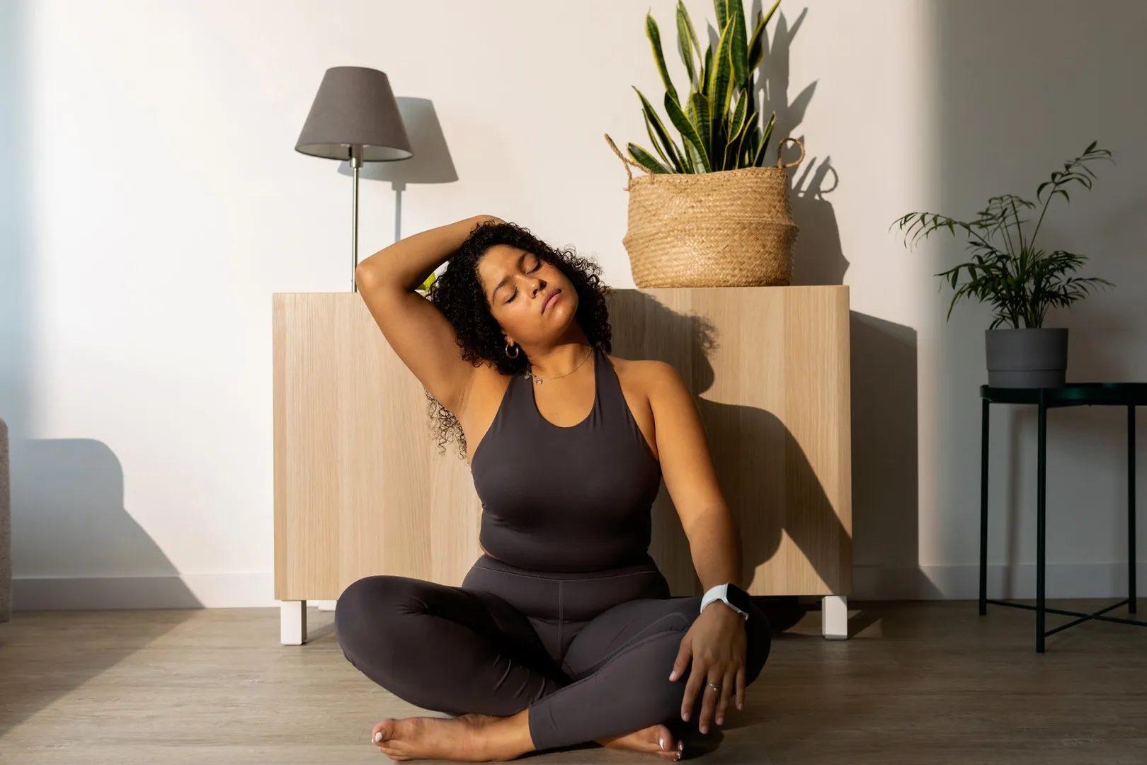 Woman sitting cross-legged in living room doing a vagus nerve reset stretch.