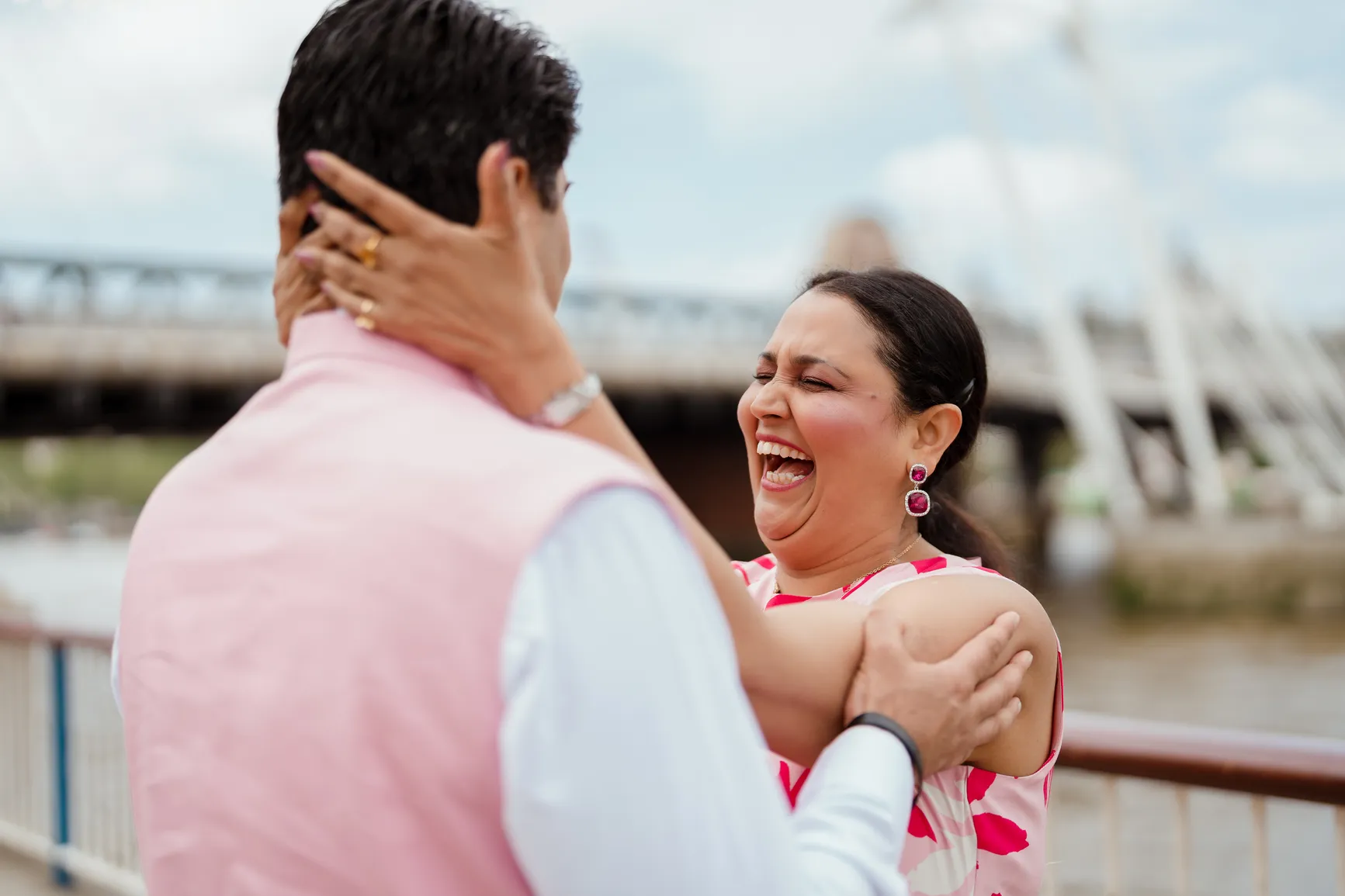 A couple stands closely together, smiling and laughing, inspiration for those looking to manifest love.