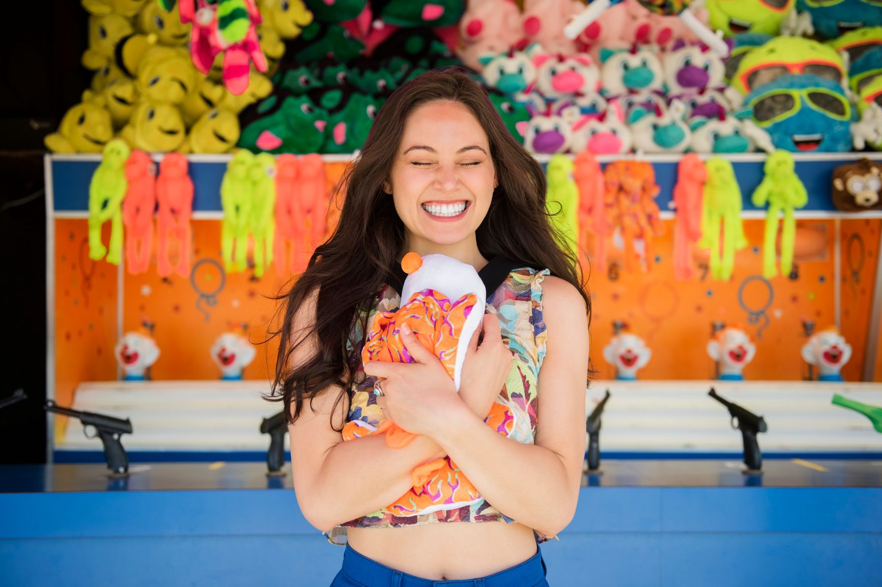 Woman smiles happily as she hugs a prize she just won at a fair