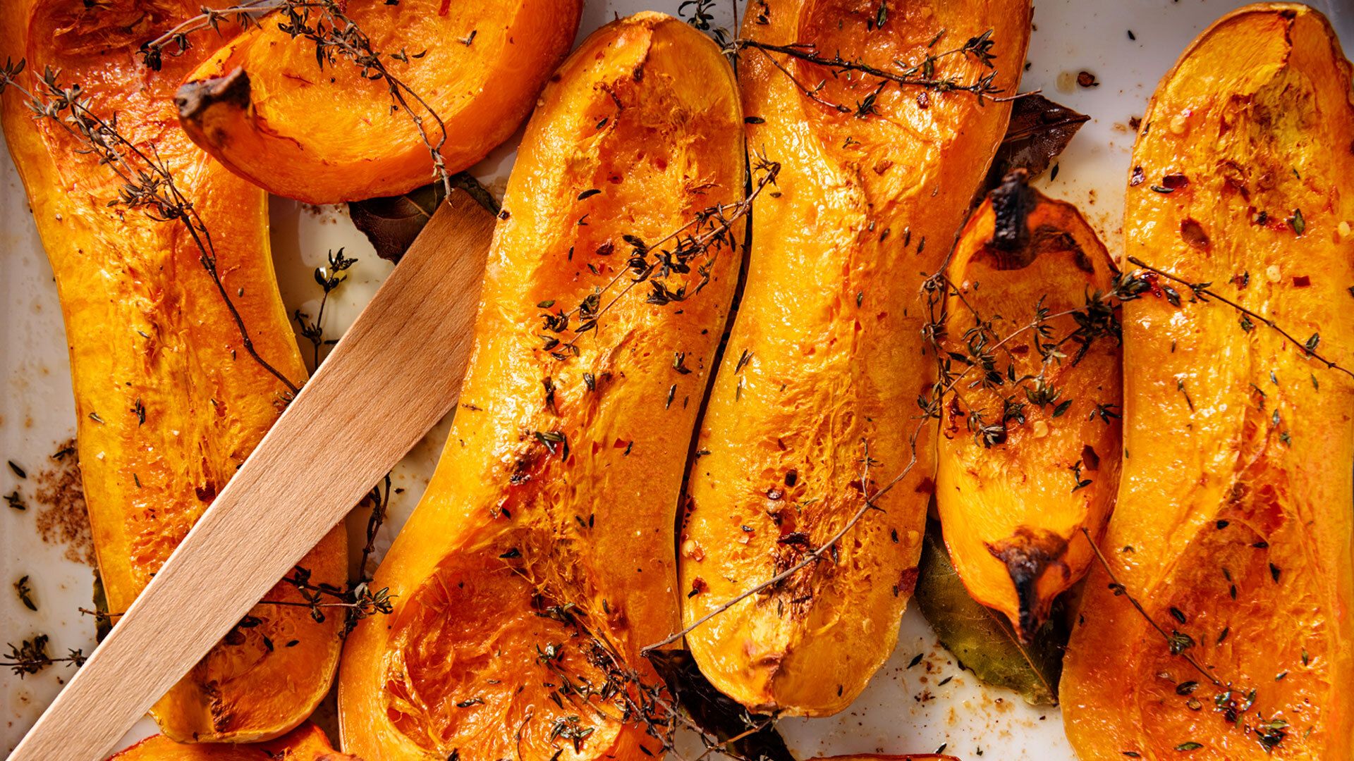 Dish of freshly roasted butternut squashes cooked until they are soft, with thyme, bay leaves and olive oil. 