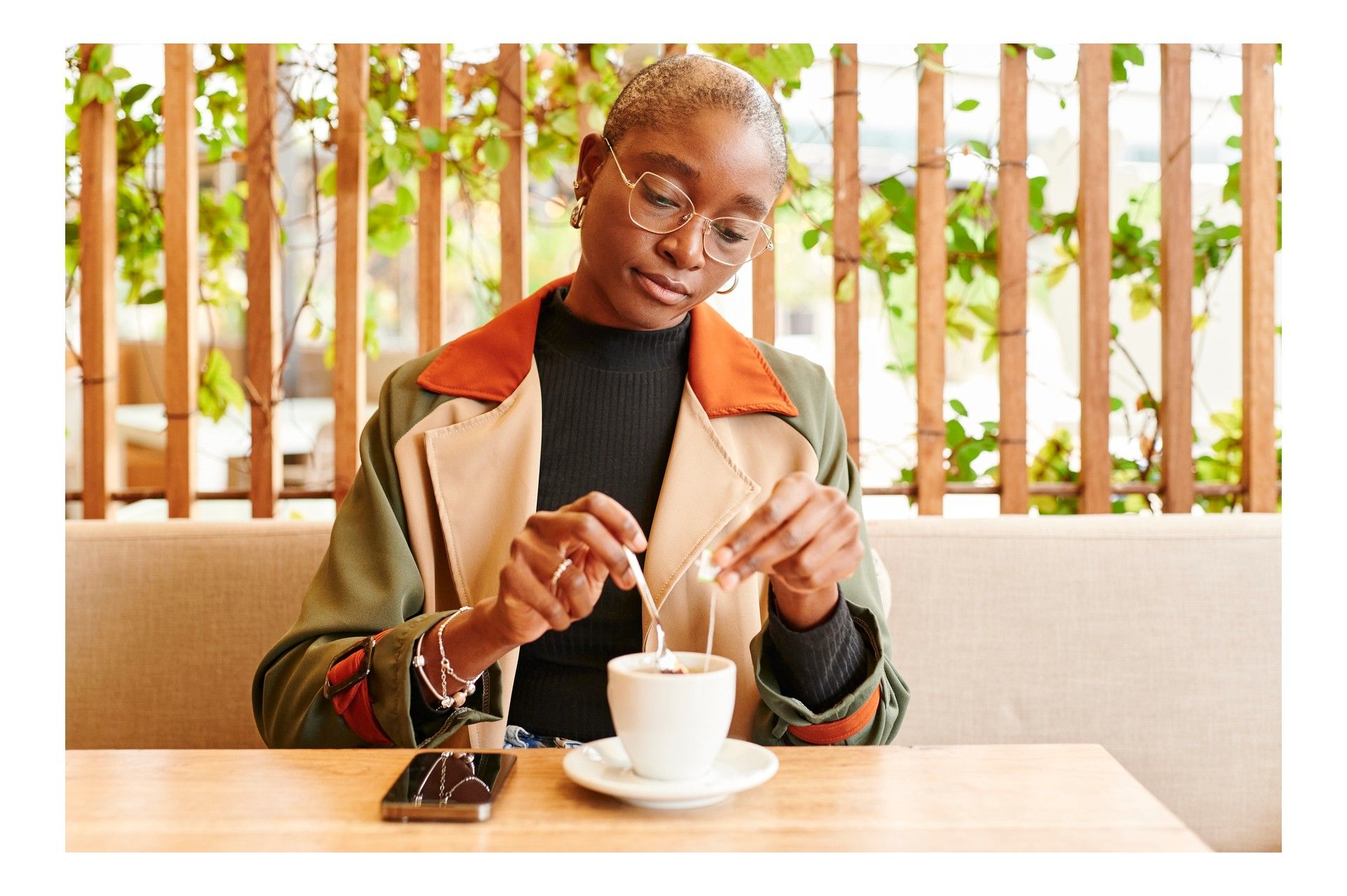 woman steeping tea in a cup at a cafe