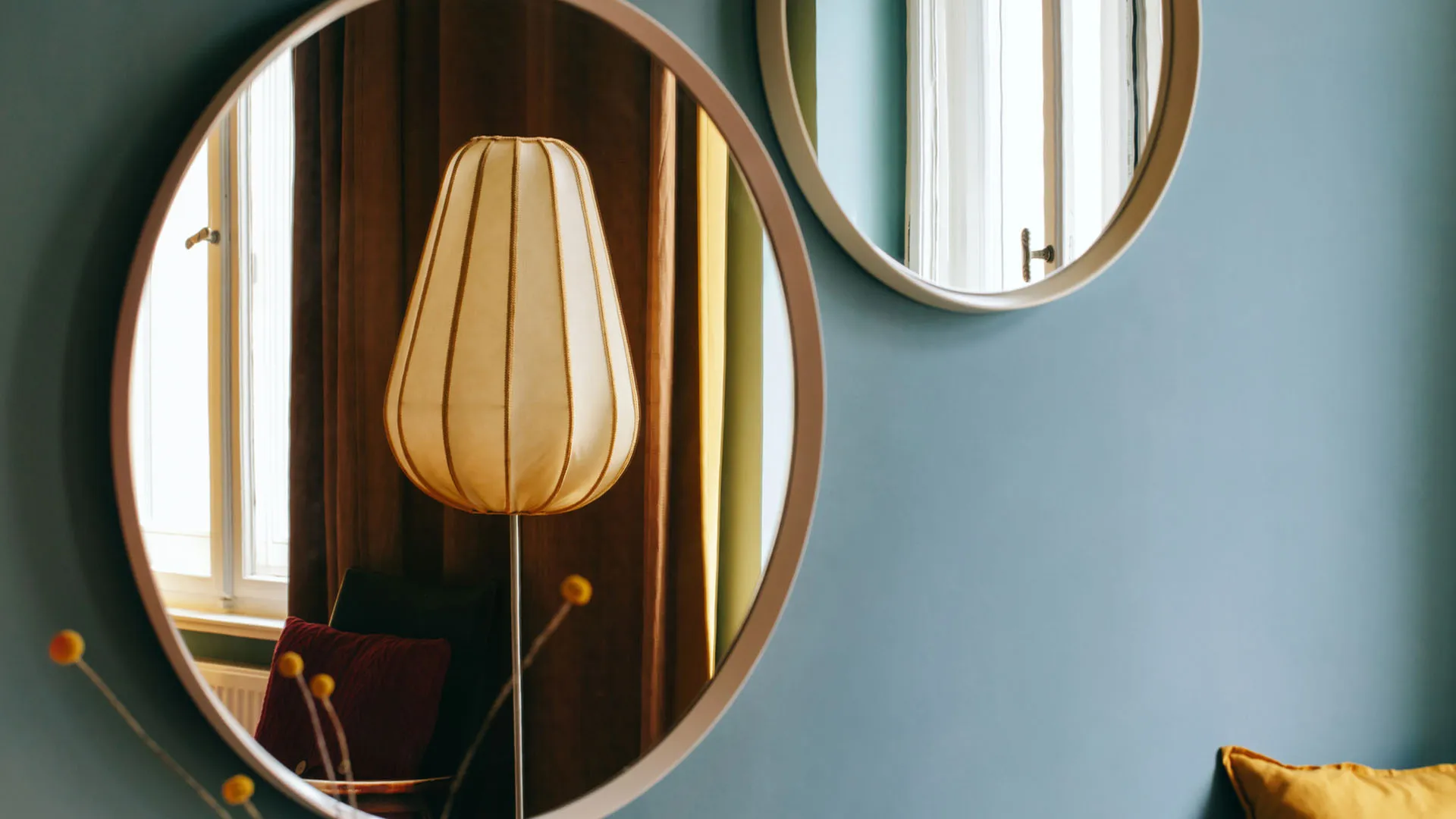 Retro lamp and round mirror on blue wall