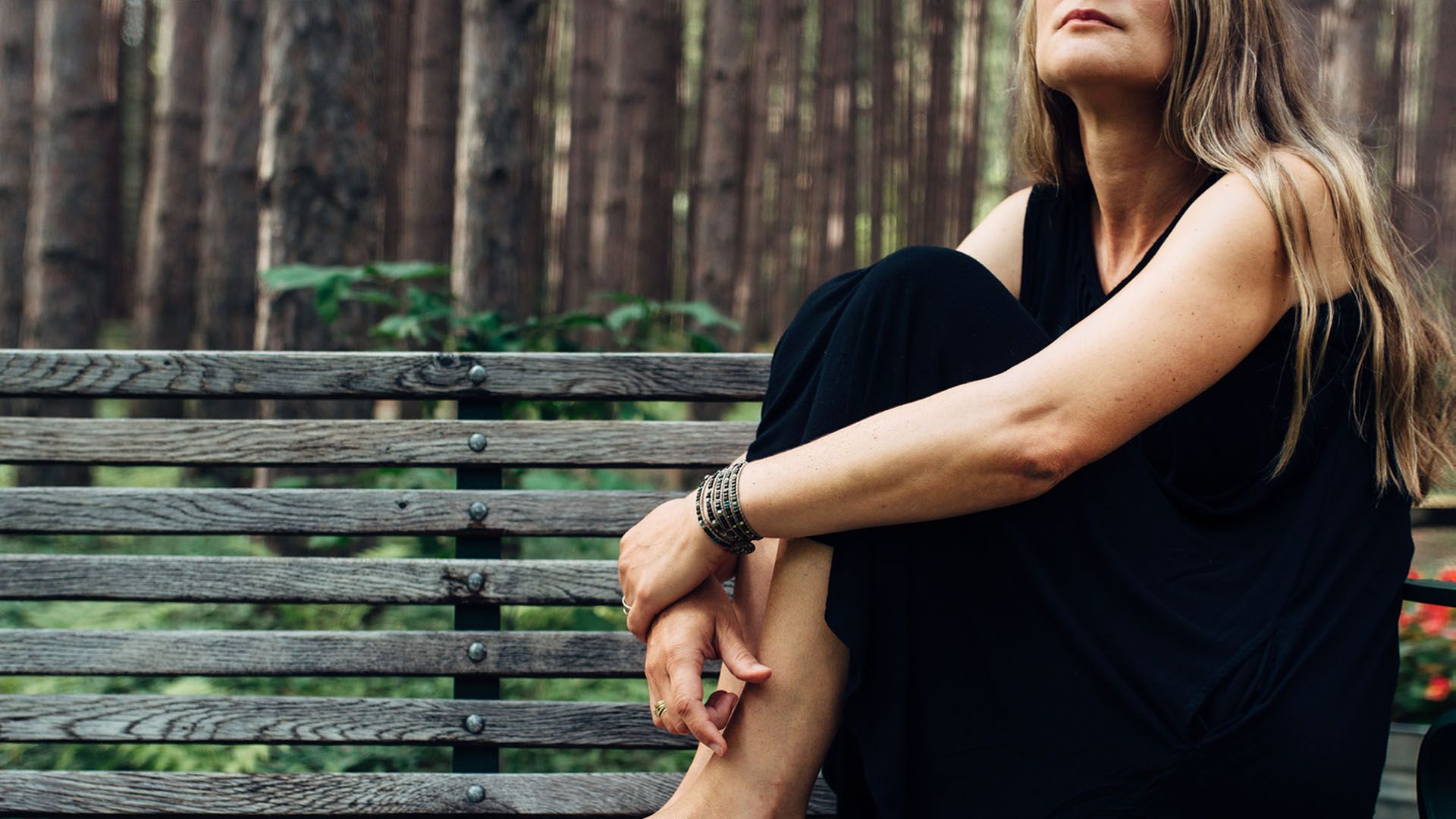 Woman sits alone on a park bench, considering a divorce and trying to accept that her marriage is over