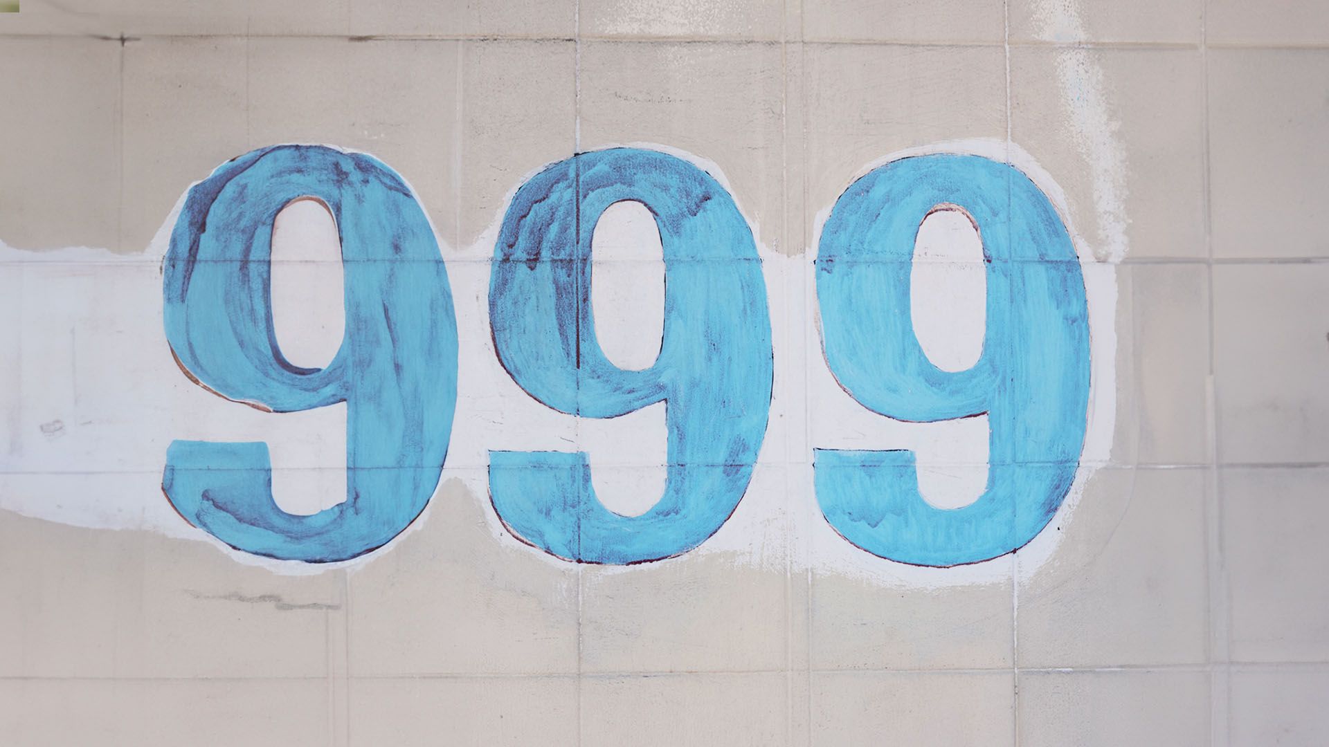 Angel number 999 on blue tiles on a white wall