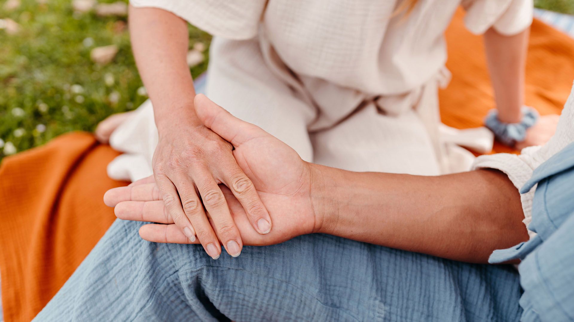 Close up of a couple holding hands, building a healthy relationship and working through a father wound of one partner.