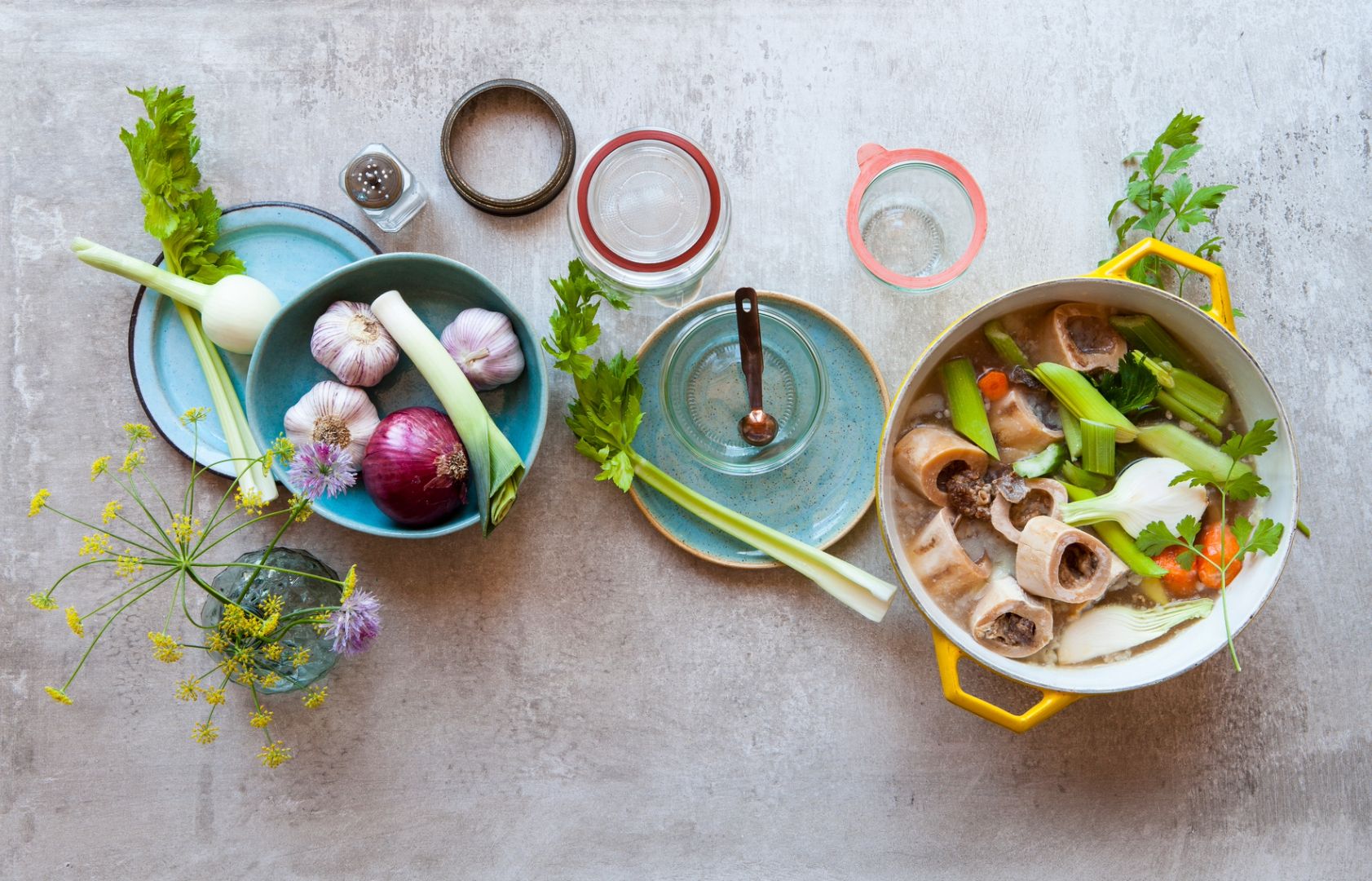 An array of bowls with fresh ingredients on a counter for preparing bone broth, a food that scientists say can help heal your body.