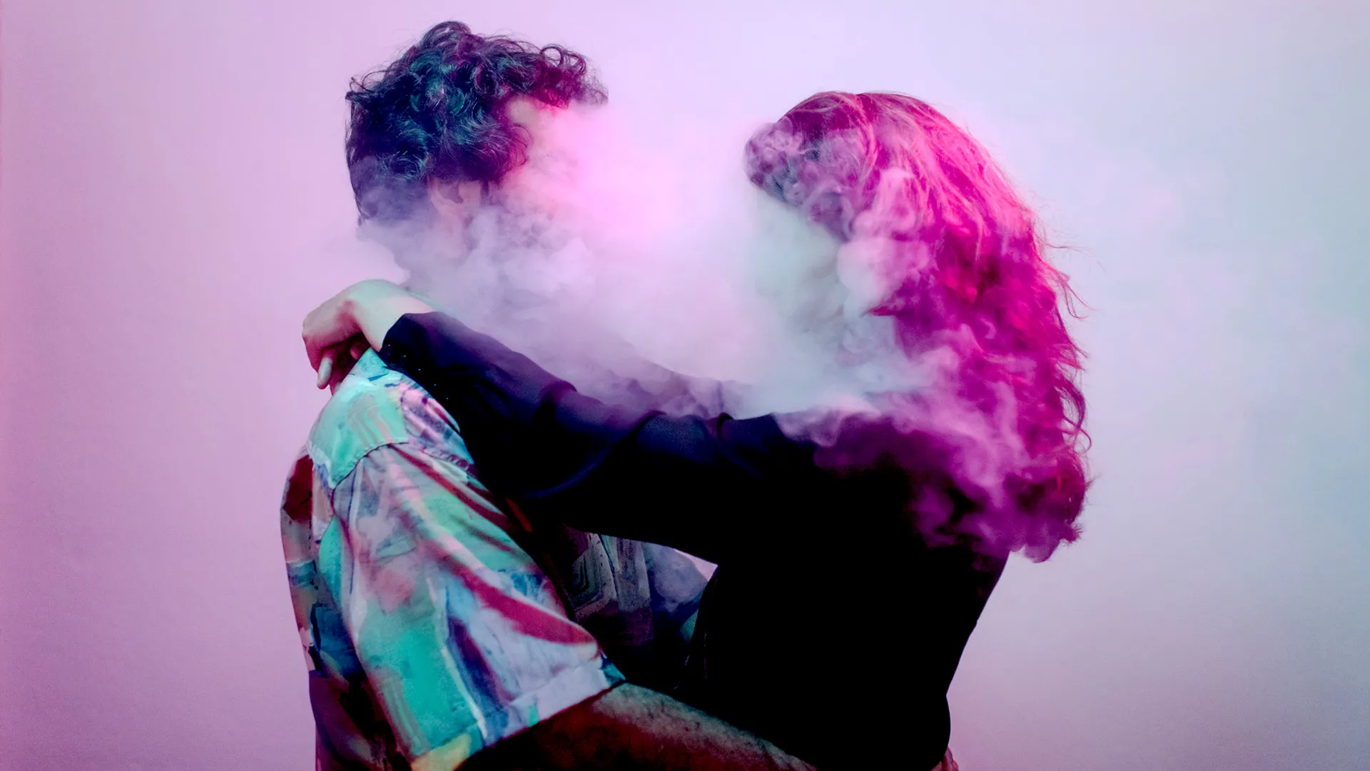 Portrait of a young couple, faces obscured, dancing inside a smoke cloud under a neon light and magical atmosphere.