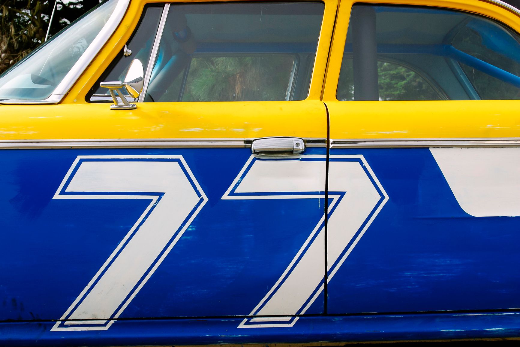 A blue and yellow race car with 77 painted on the side. That’s one example of angel number 77 or angel number 777, and if you see them frequently, it may be a message from above.