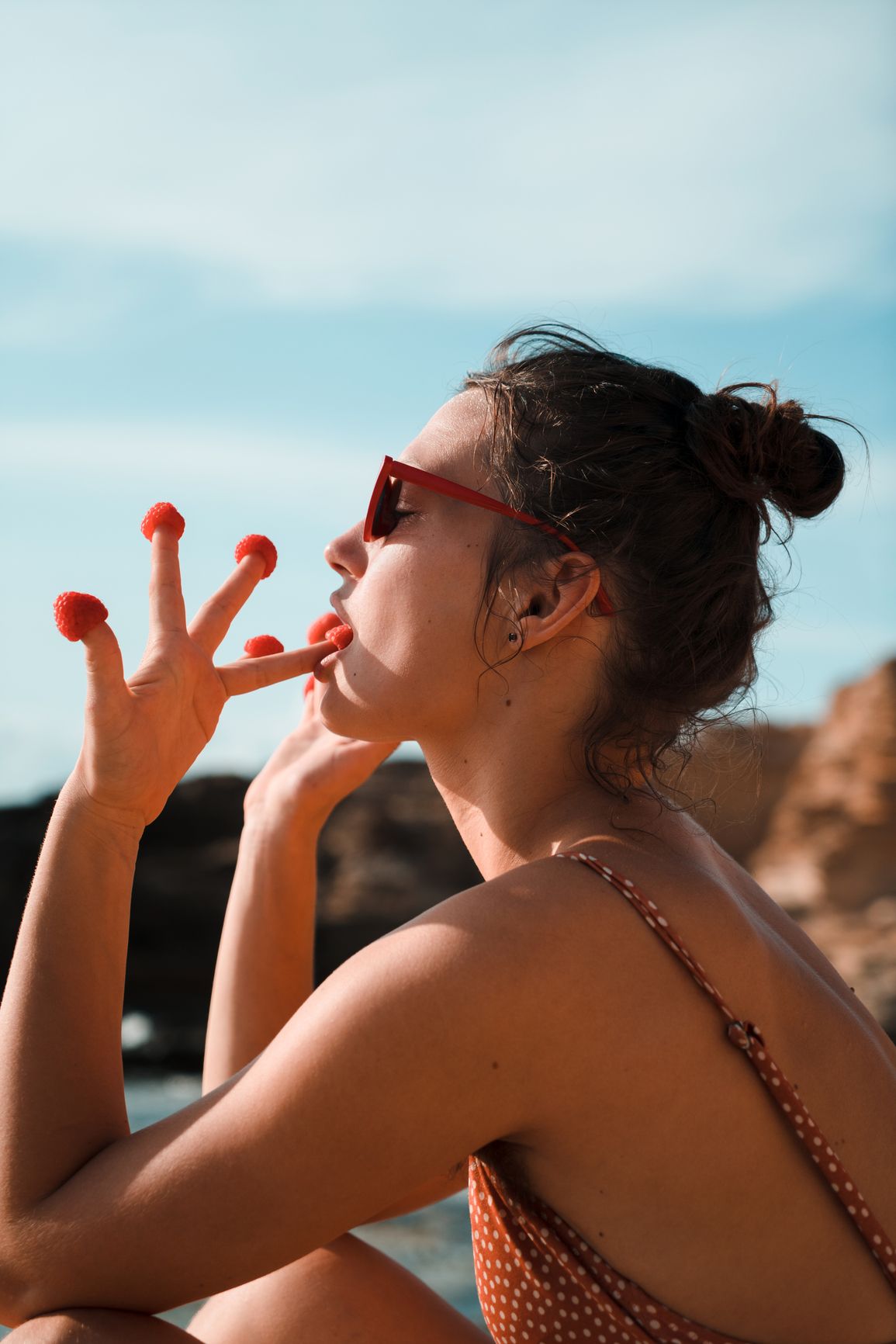 Woman outdoors eating raspberries 