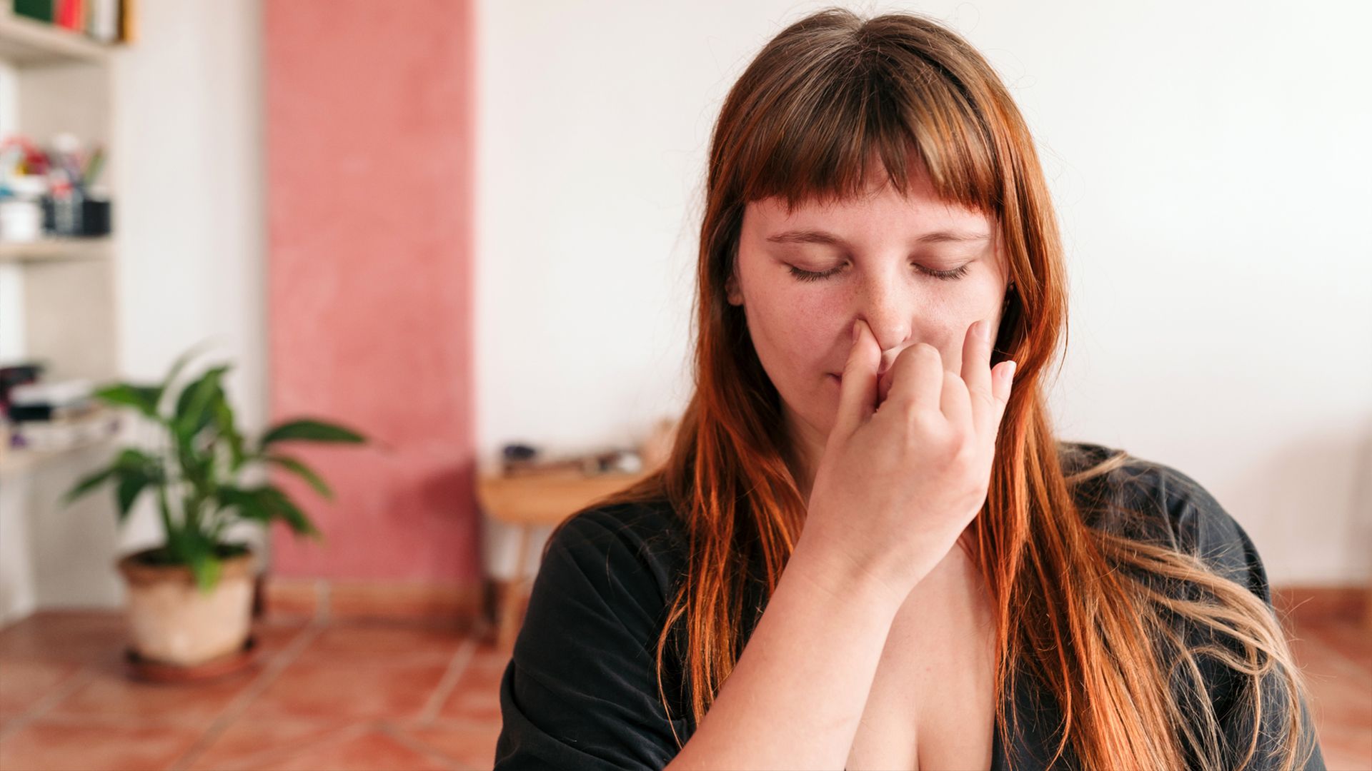 Woman practicing alternate nostril breathing or nadi shodhana pranayama.